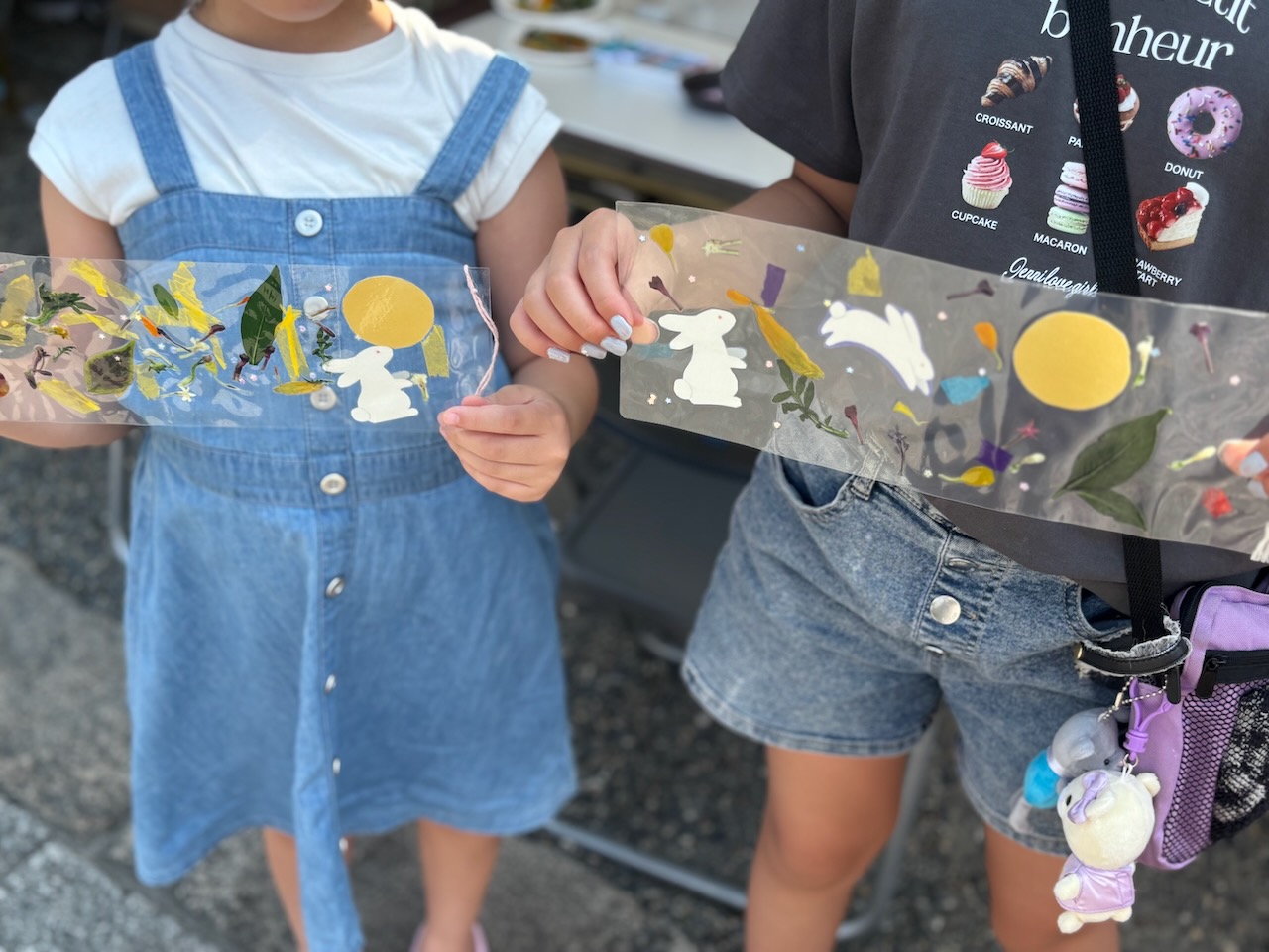 押し花や紙花を使って仕上げた短冊サイズの栞を手にする子どもたち
